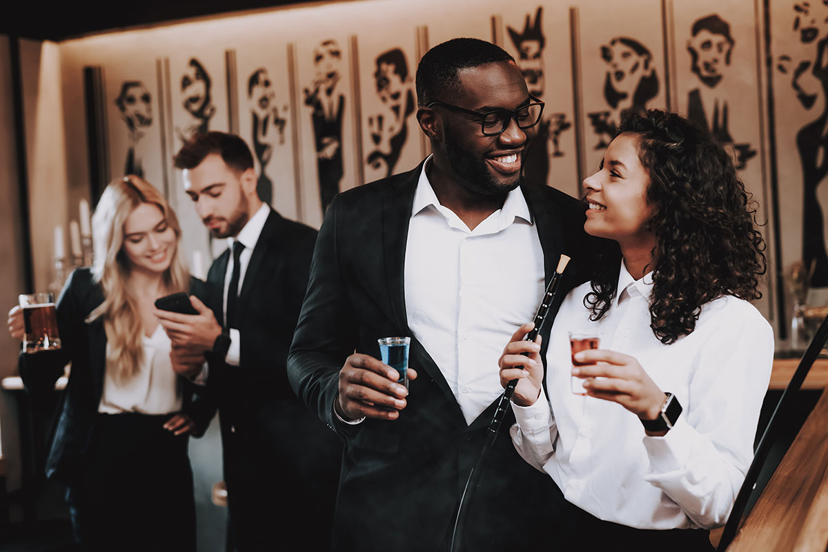 two men talking with paired off girls